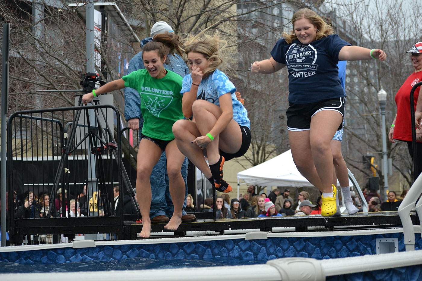 Students jump into a pool of cold water at the Pittsburgh Polar Plunge